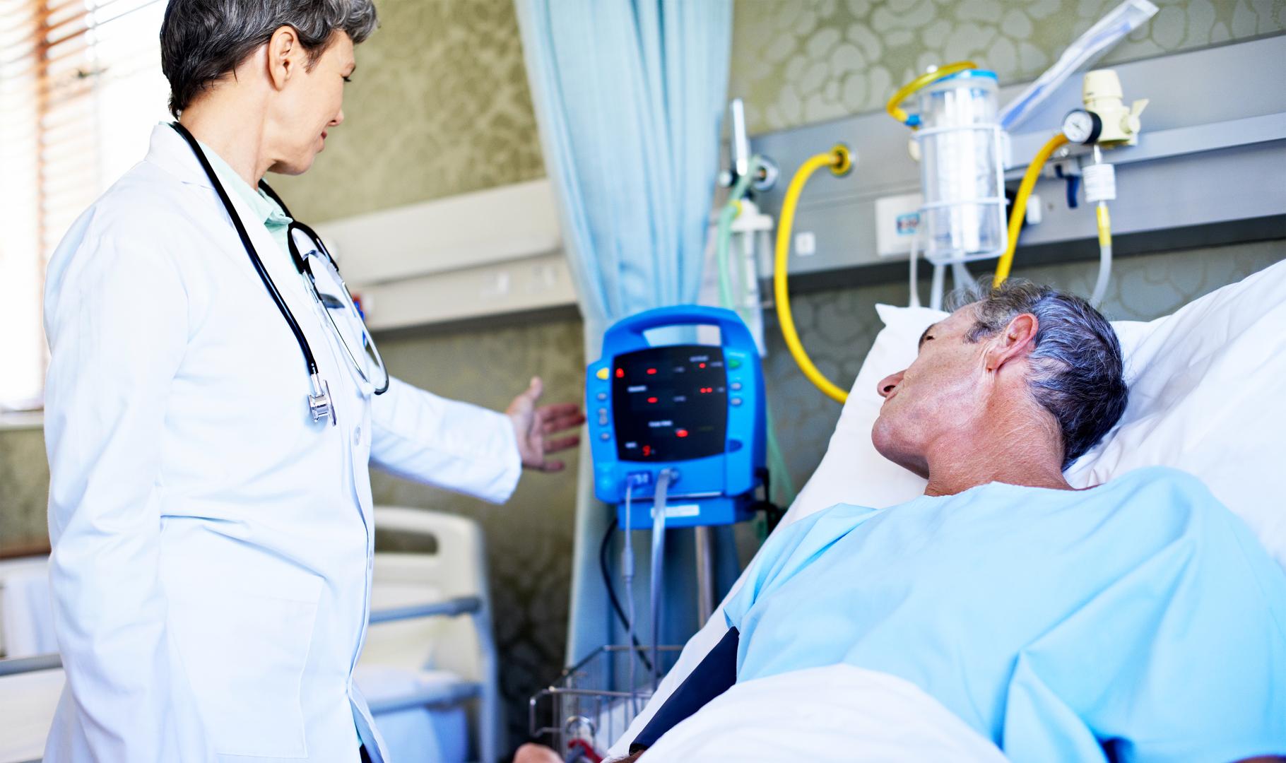 Photo of a healthcare professional with a patient on a hospital bed.