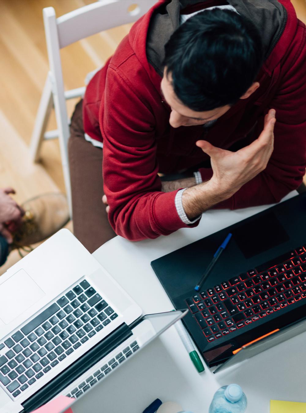 Two employees in a meeting with their laptops