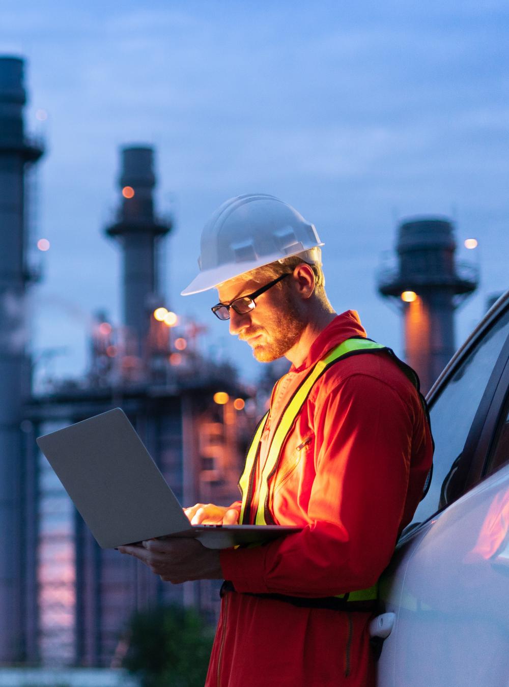 Engineer on a laptop at an oil refinery