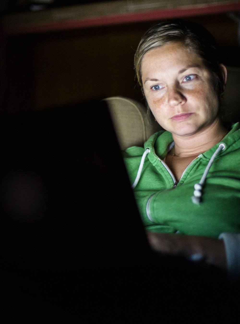 Woman on a computer in the dark