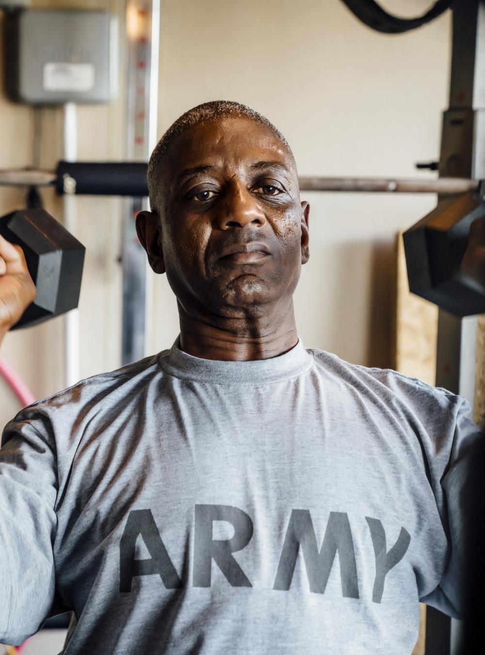 Middle-aged Army veteran working out by lifting weights