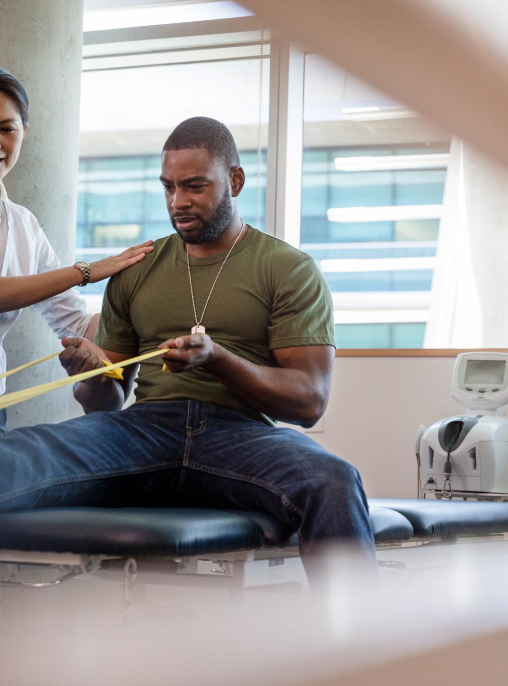 Veteran doing physical therapy supported by a therapist
