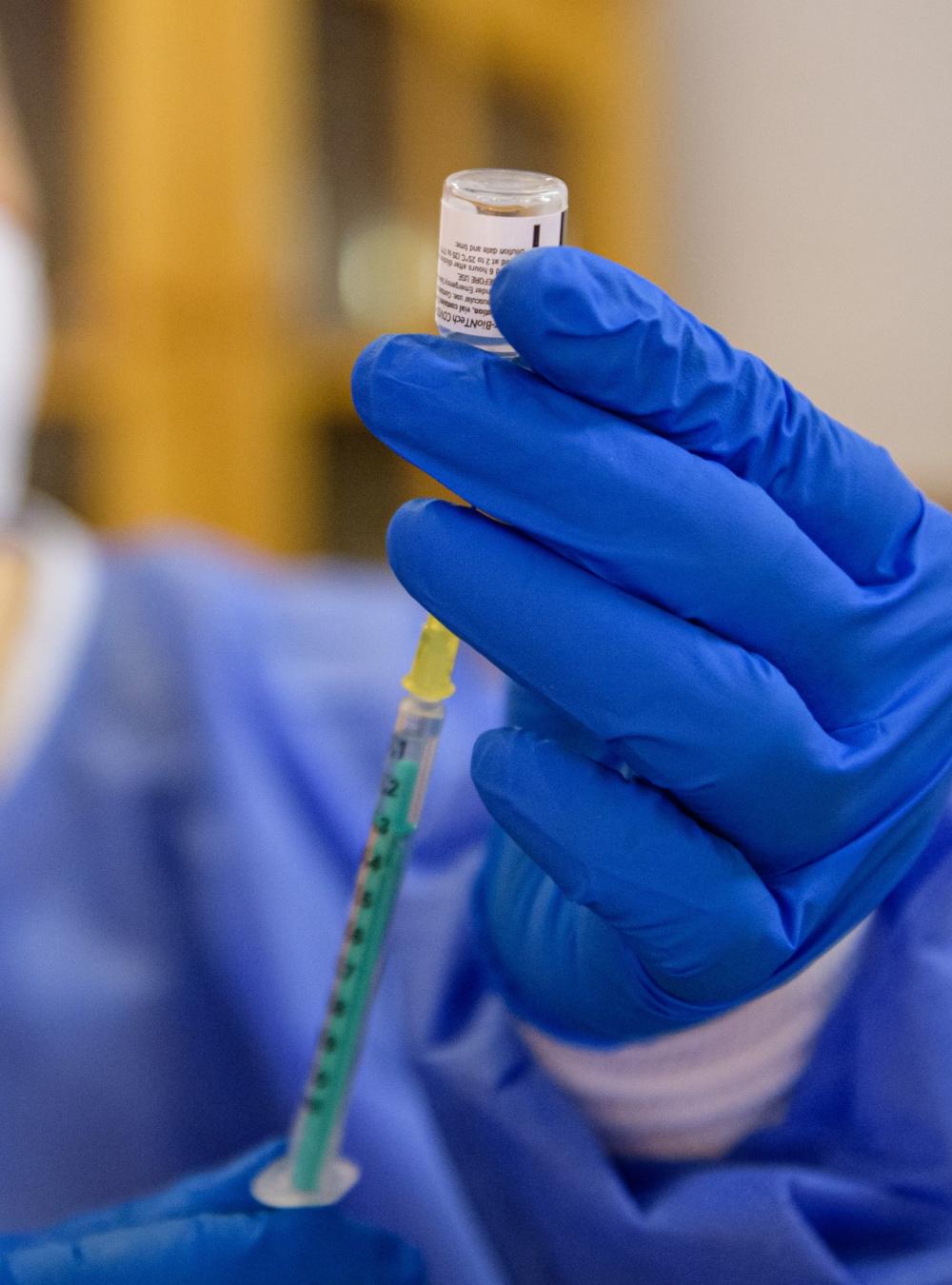 Healthcare worker drawing a medication into a syringe