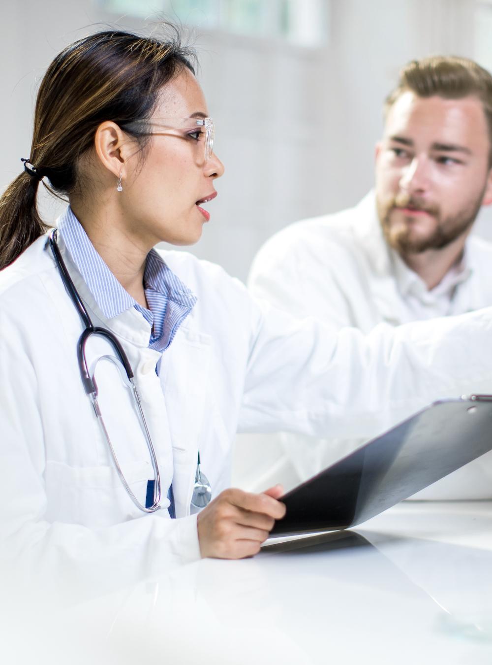 Two clinicians discussing data on a computer monitor
