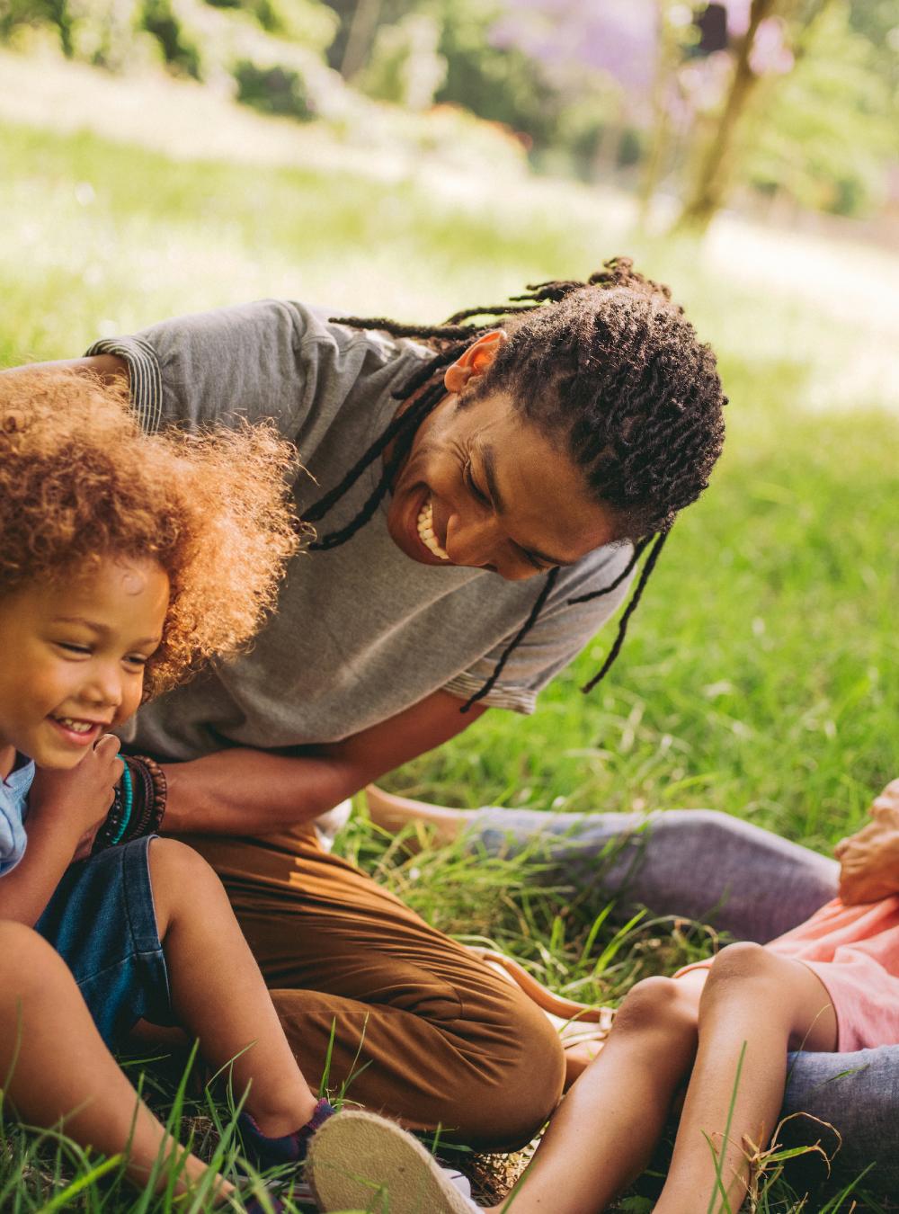 Parents and their two kids enjoying time together outside in a park