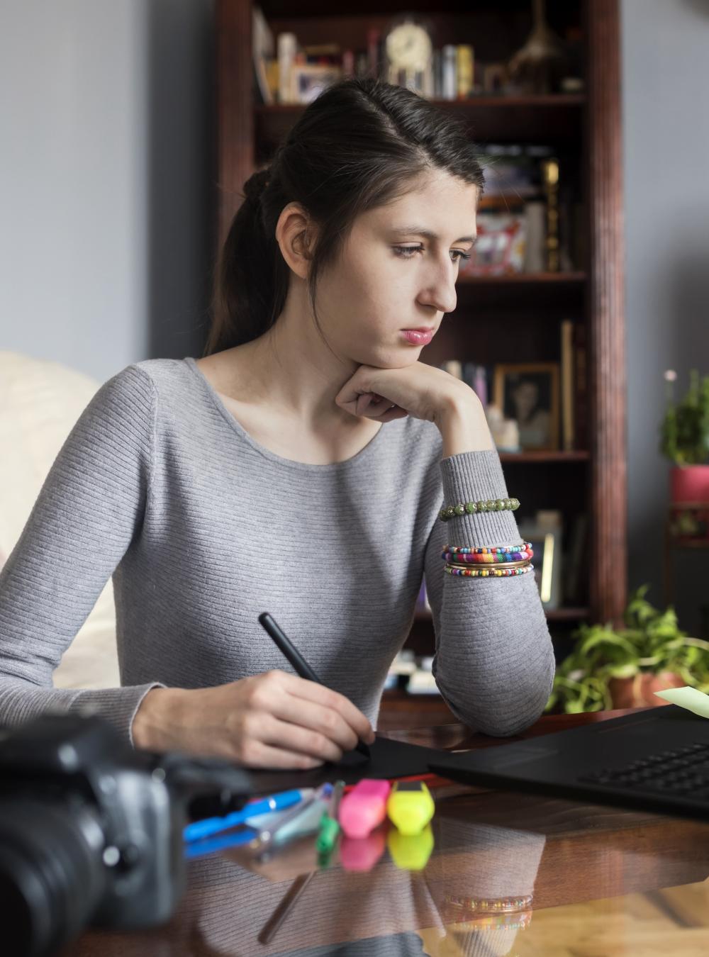 Woman with a hearing impairment using assistive technology as she works on a laptop
