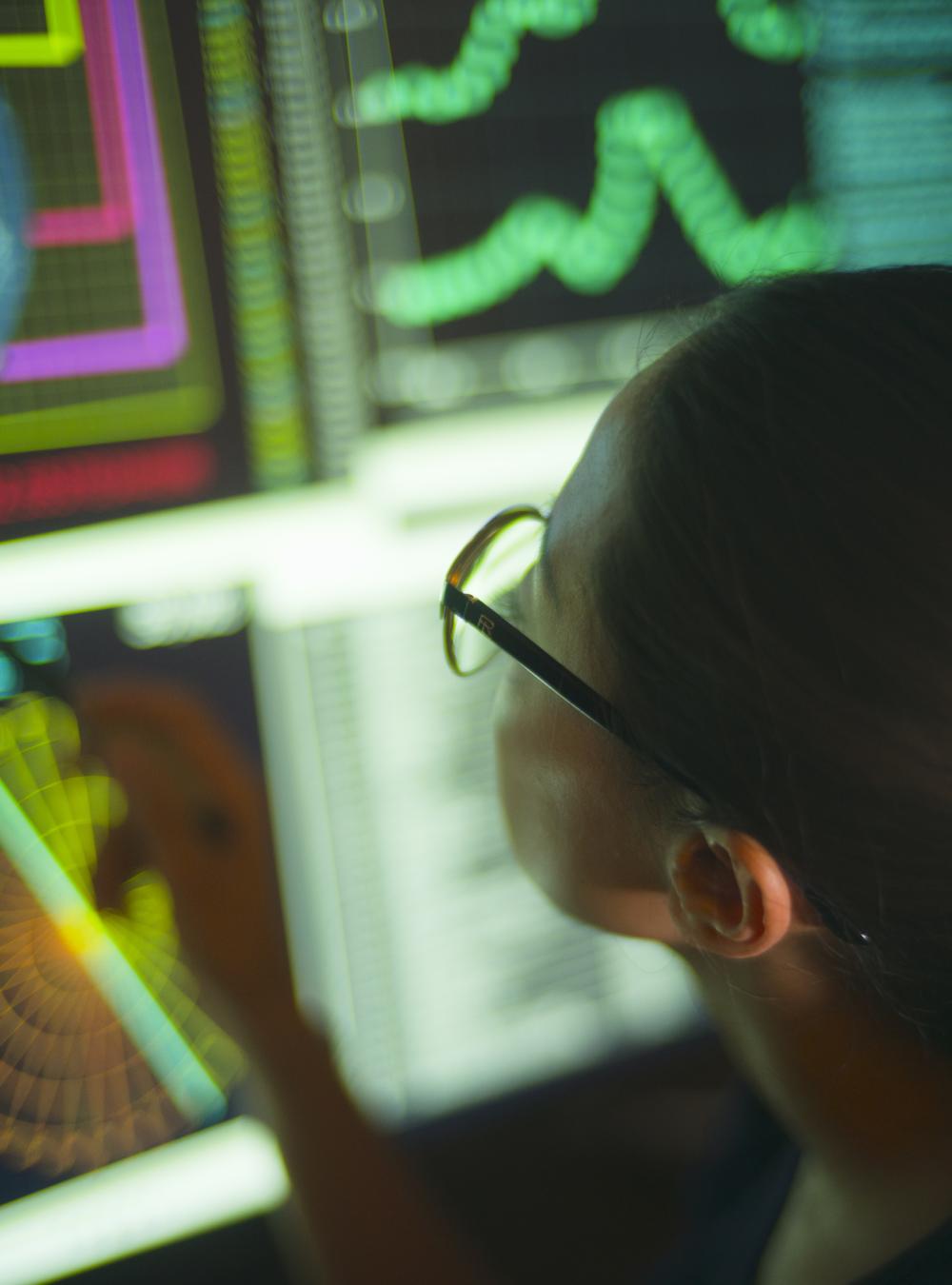 Woman working in the intelligence field, viewing monitors of data