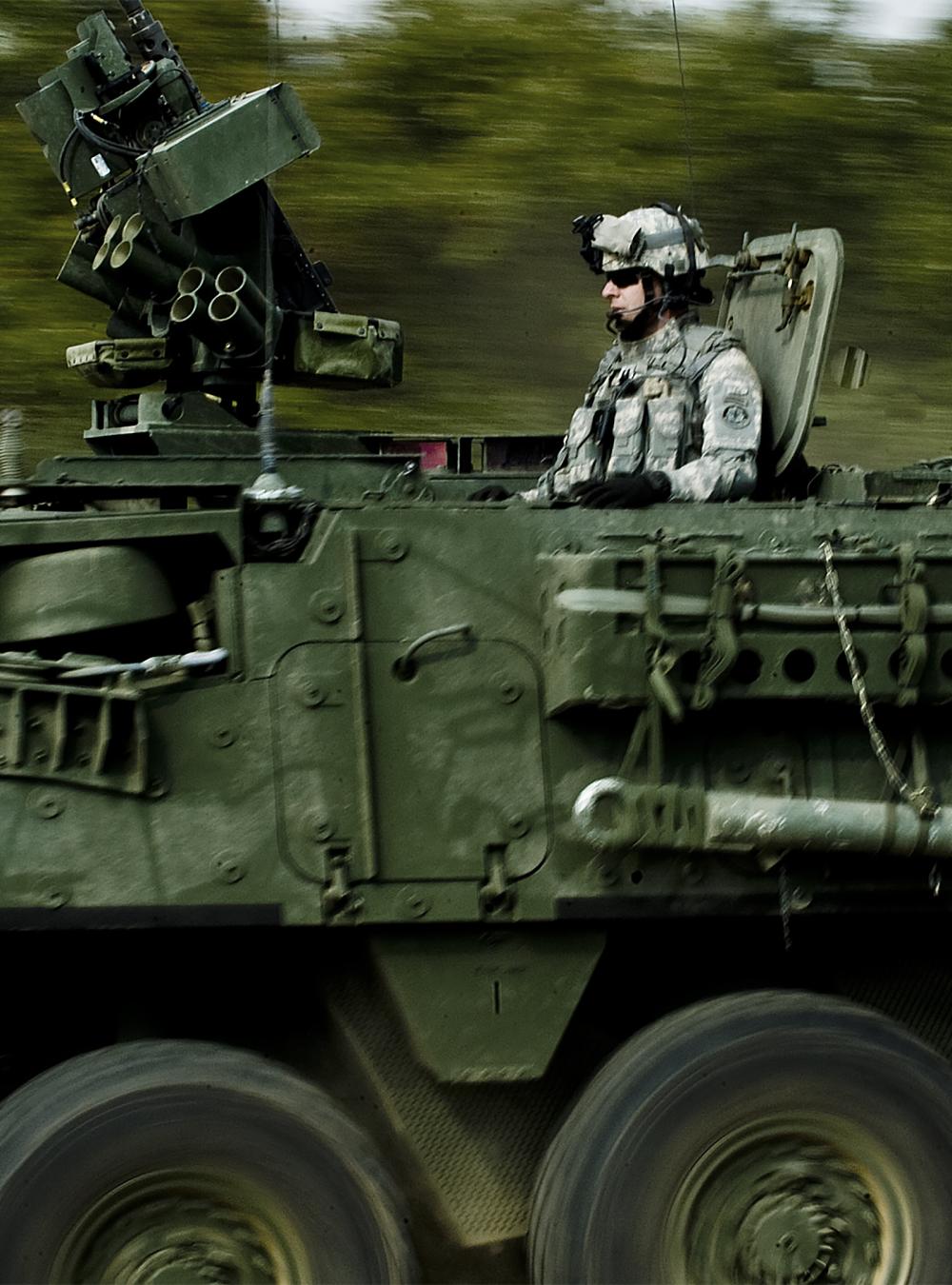 Soldiers on a moving Stryker vehicle