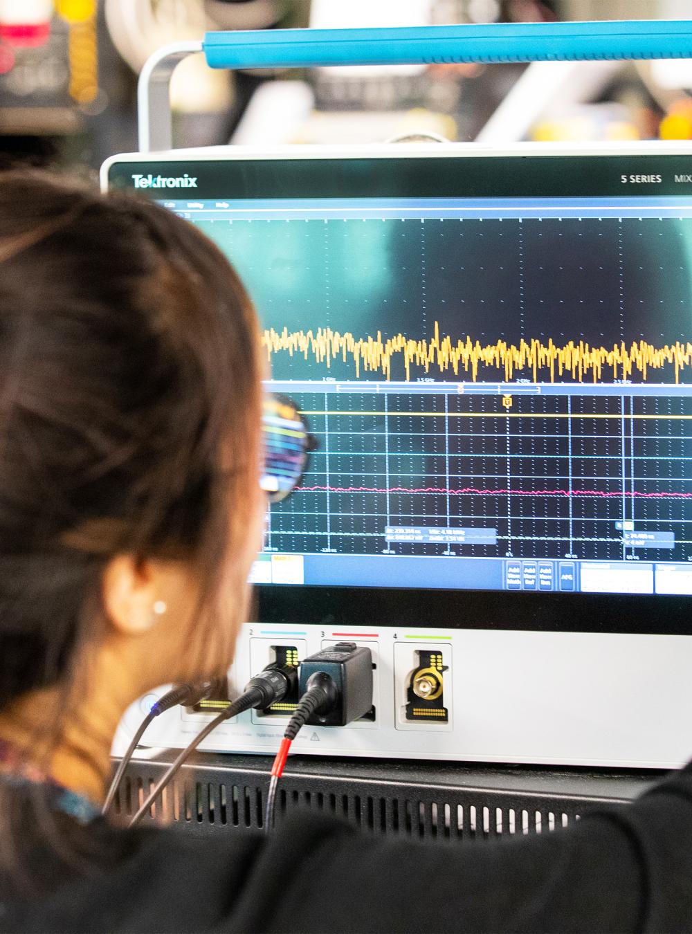Female employee using an oscilloscope in the Bedford lab