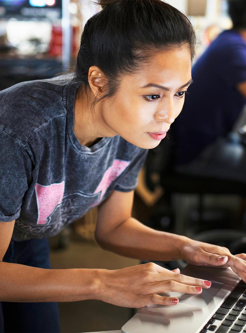 Woman in a lab space typing on a laptop