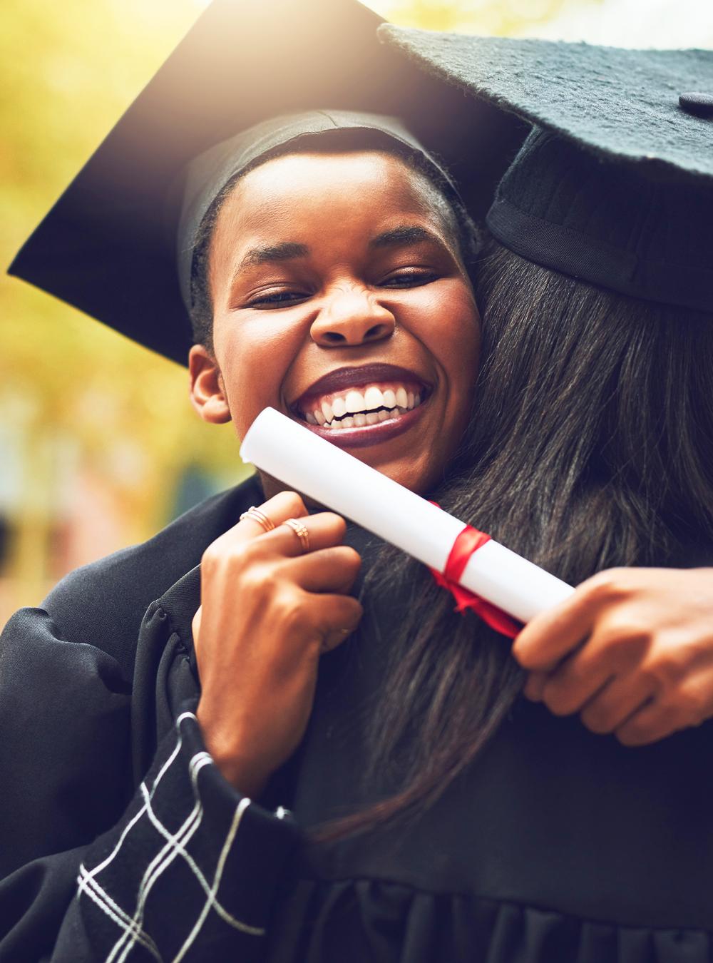 Shot of two graduates embracing each other on graduation day