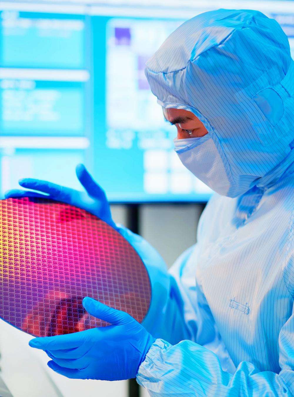 Technician checks a wafer at a semiconductor manufacturing plant