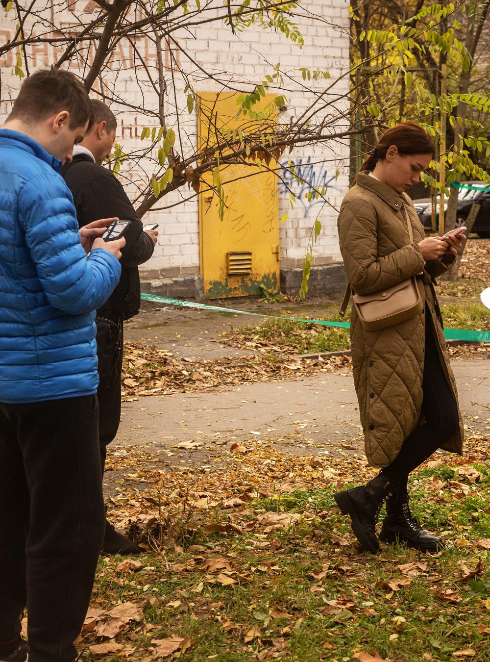 Kherson, Ukraine residents use their phones in an area of the city center that has temporary phone network and a Starlink device