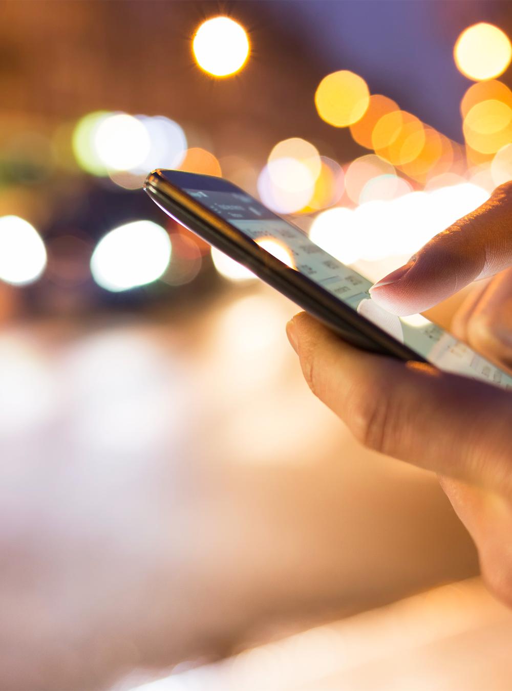 Woman holding a cellphone at night