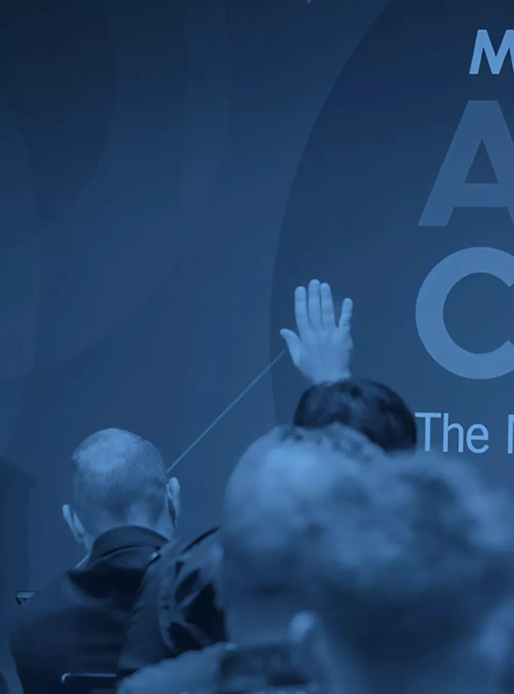 A group of people in a conference room listening to a speaker at the ATT&CKcon cybersecurity conference