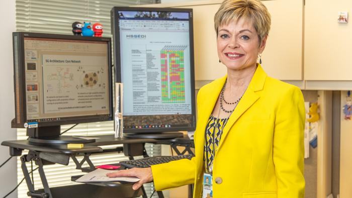 Terri Phillips standing in front of her computer