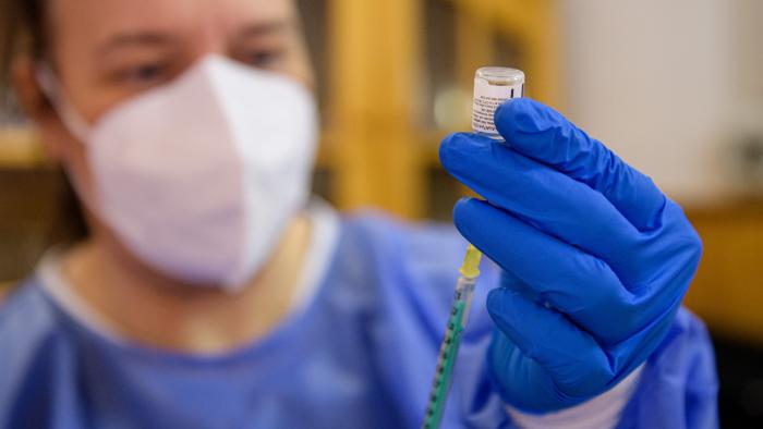 Healthcare worker drawing a medication into a syringe