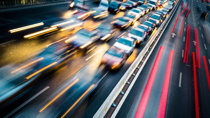 Cars in motion on a dark highway, showing the speed of traffic