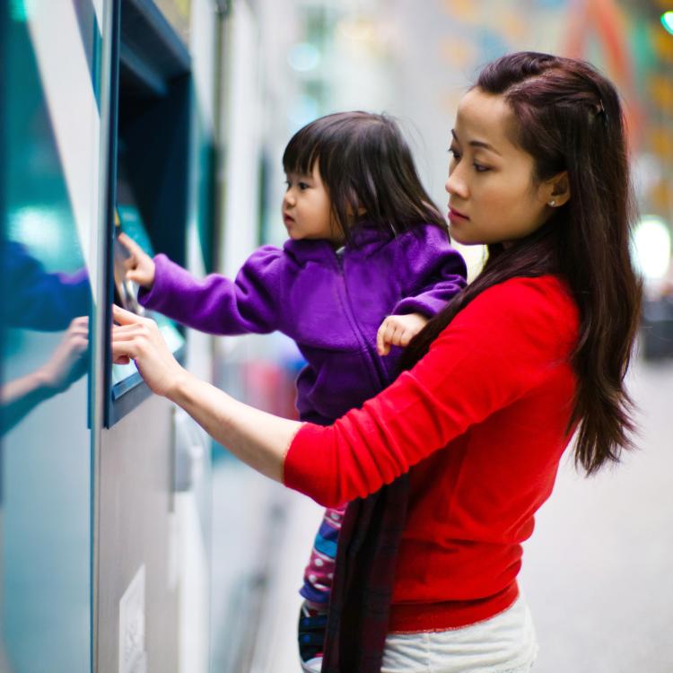 Mother and daughter using an ATM machine